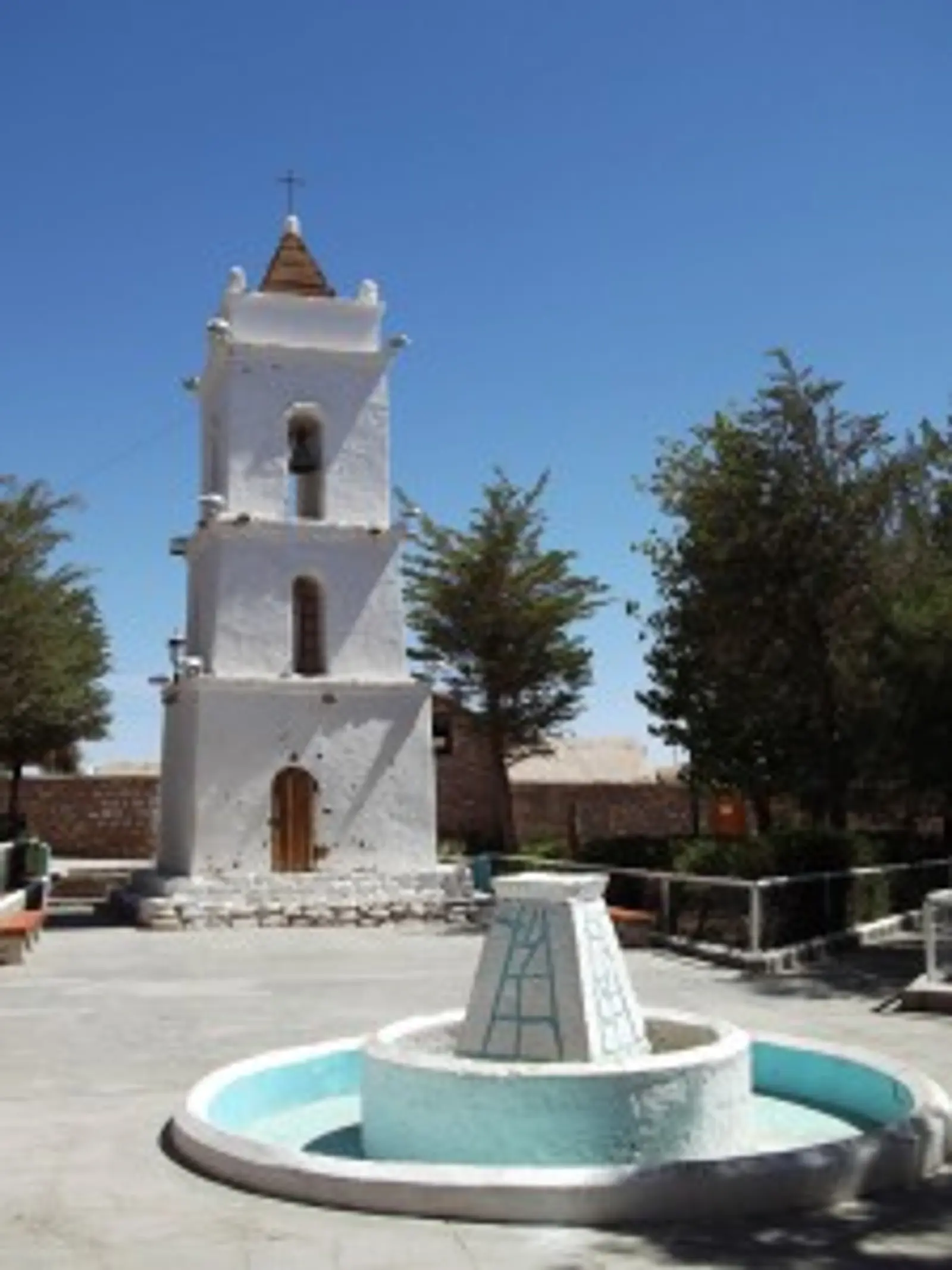 Torre do sino e fonte branca em Toconao