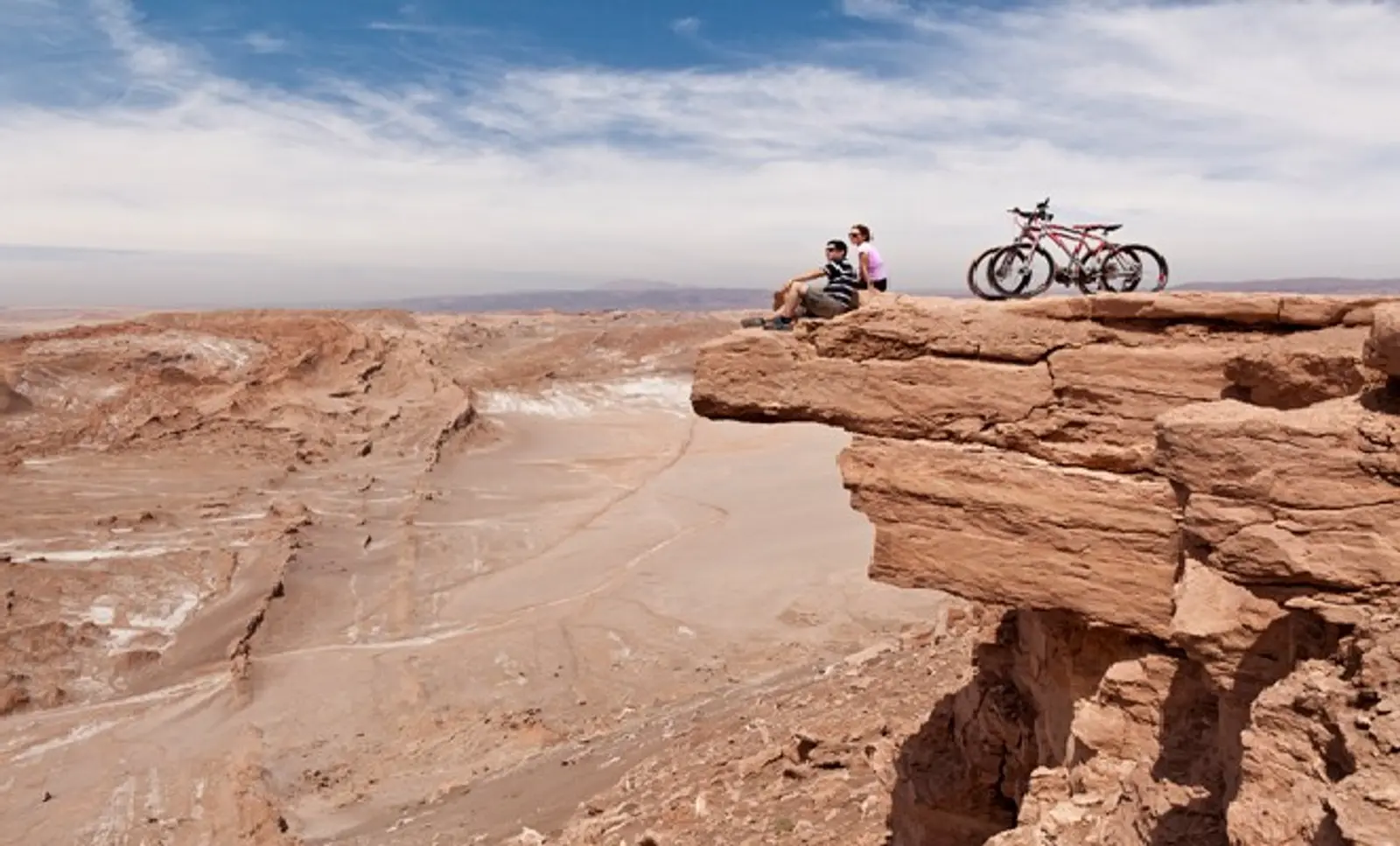 Dois viajantes e suas bicicletas em um mirante no Atacama