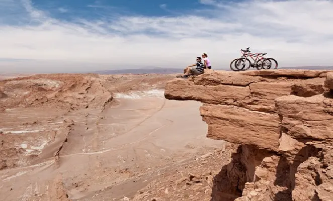 Dois viajantes e suas bicicletas em um mirante no Atacama
