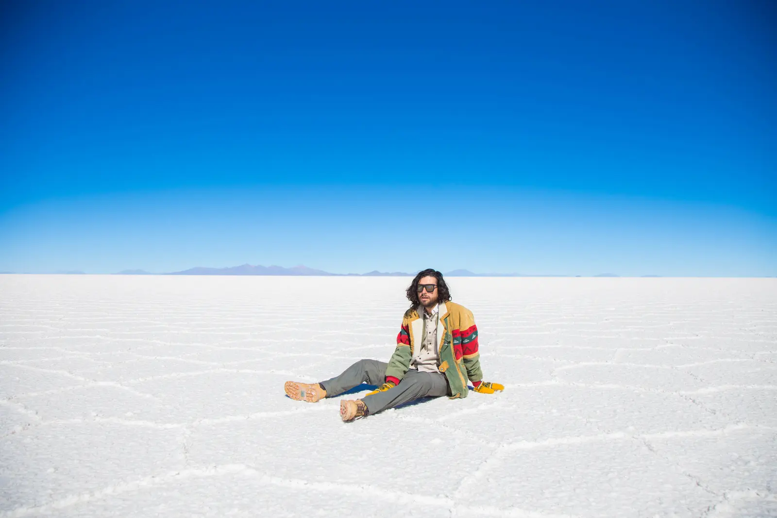 Homem sentado no Salar de Uyuni