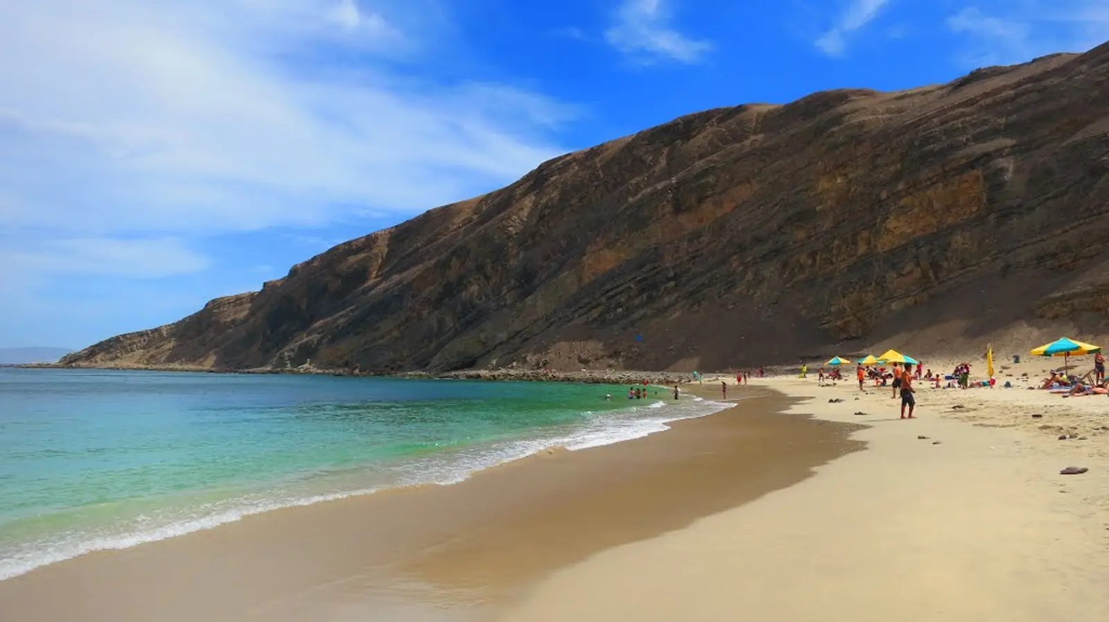 Playa tranquila frente a roca gigante