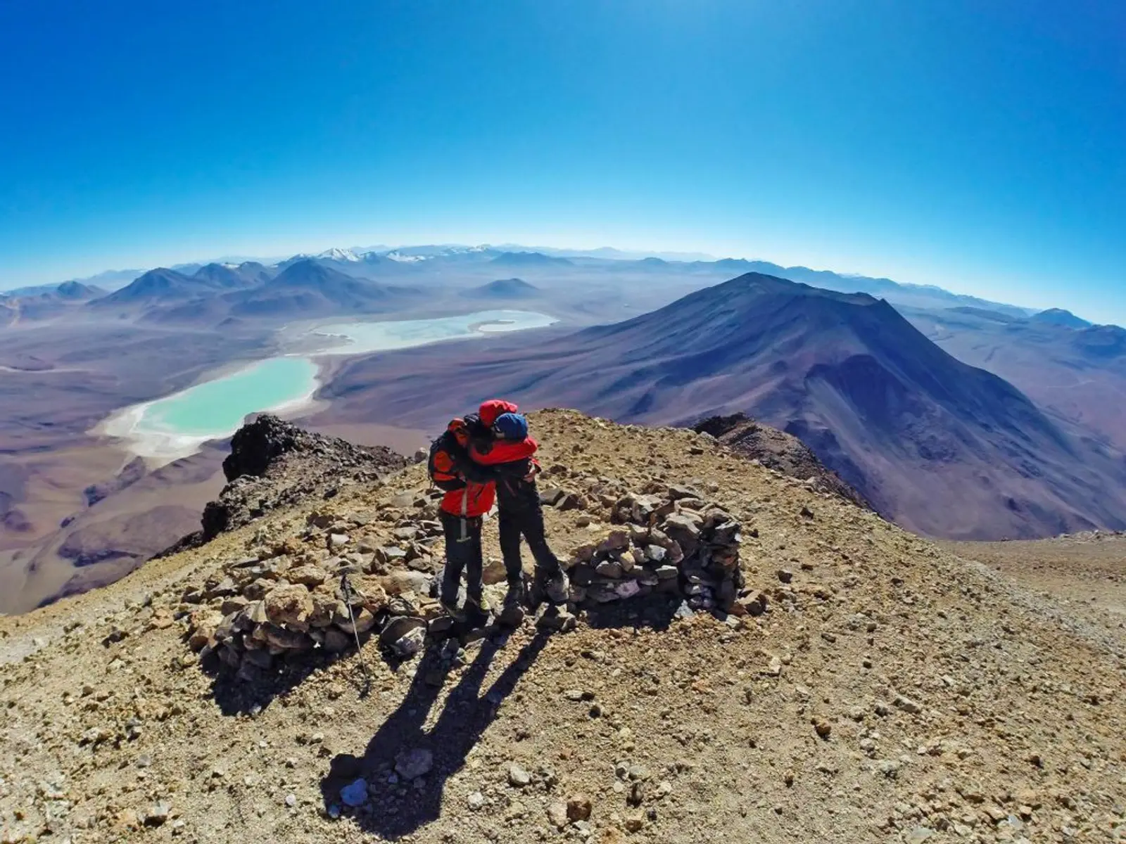 Dos personas abrazandose en la cima de un volcán