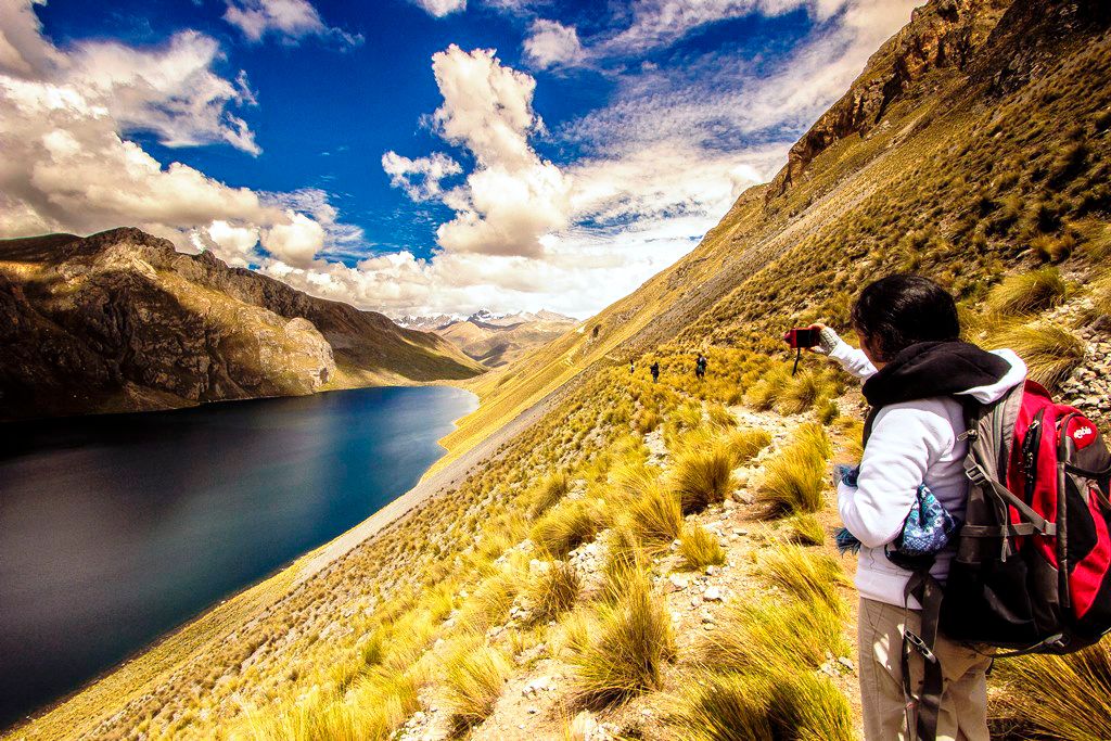 Joven tomando fotografía en paisaje de trekking desde Lima
