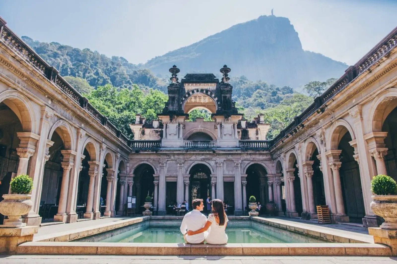 Pareja frente a construcción colonial y piscina