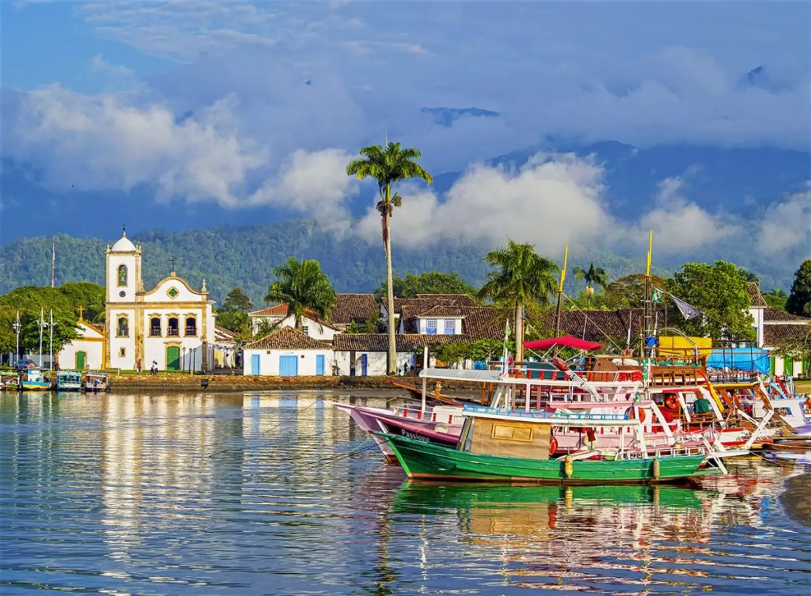 Iglesia frente a mar y barcos de colores