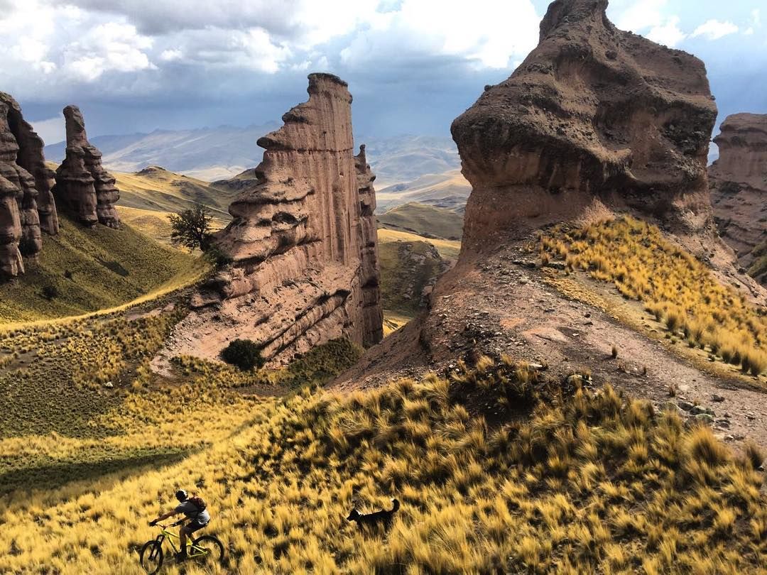 Ciclista bajando por ladera con formaciones rocosas espectaculares