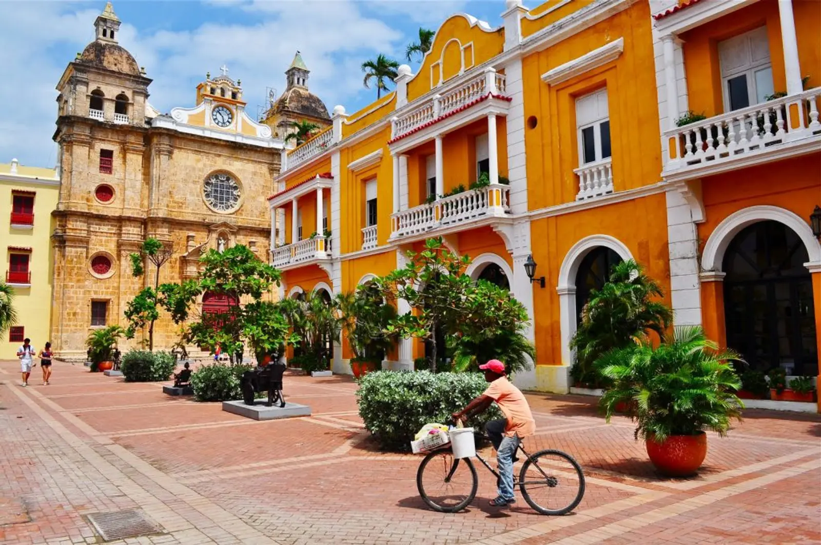 Joven andando en bicicleta por ciudad colonial en cartagena
