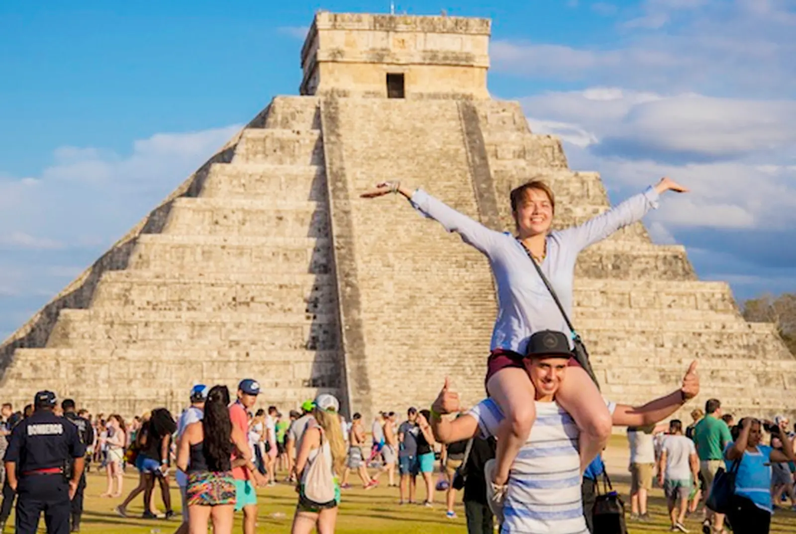 Dos turistas posan frente a pirámides de chichen itzá