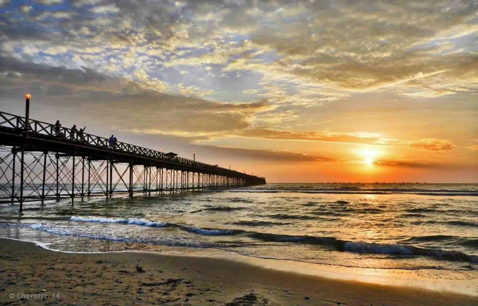 Gran muelle en medio del atardecer en la playa