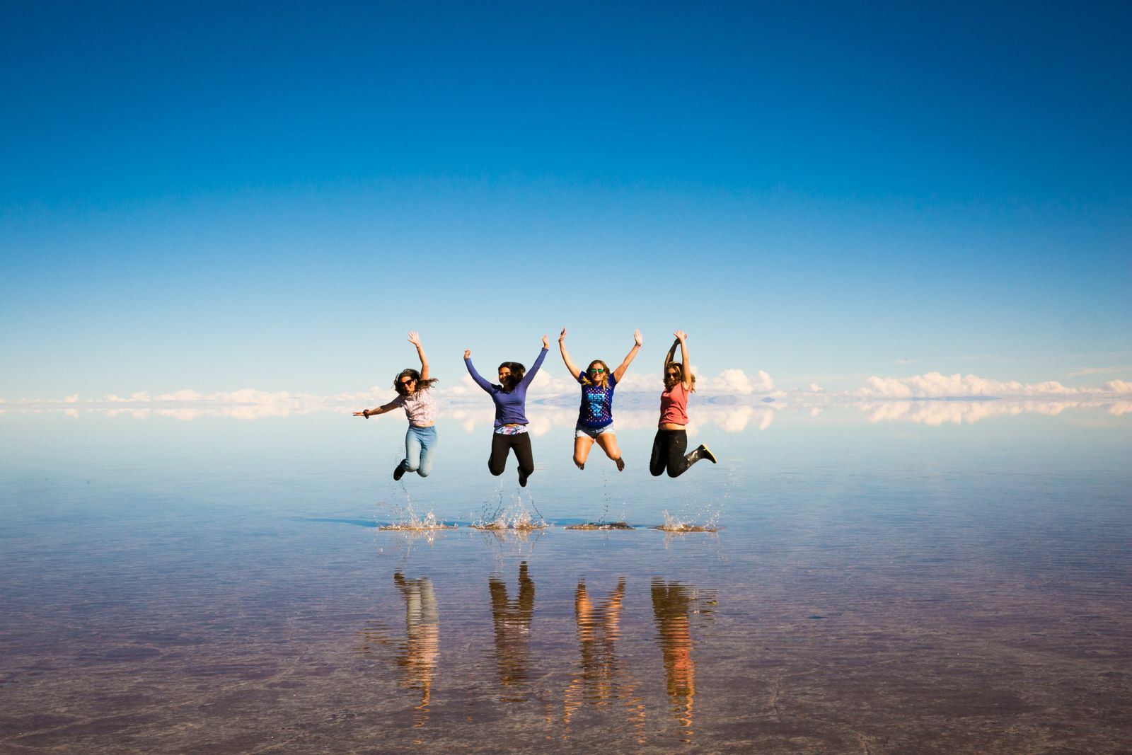 Viajeras en un salar que refleja el cielo