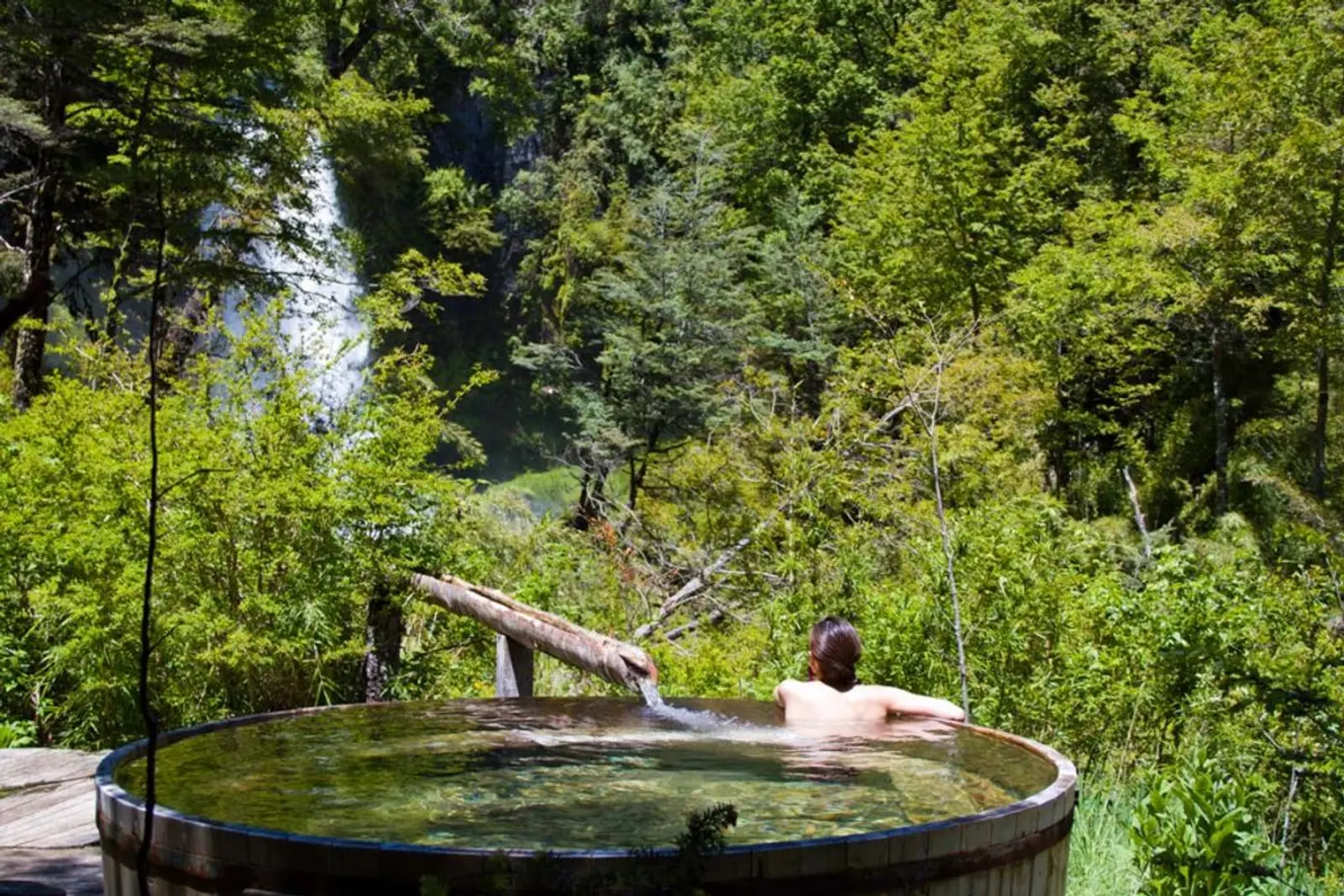Persona bañandose en terma en medio del bosque de pucón