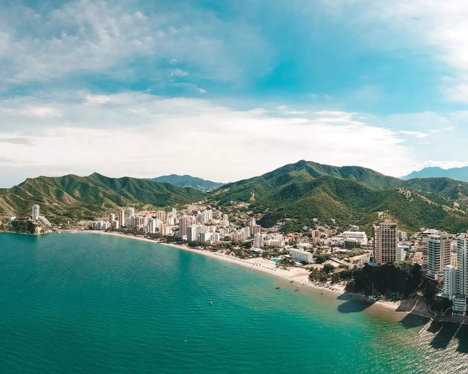 Playa frente a hermosa ciudad y cerros
