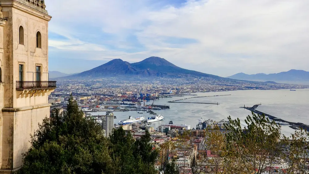 Vista de una ciudad frente al agua y volcán en Napoles