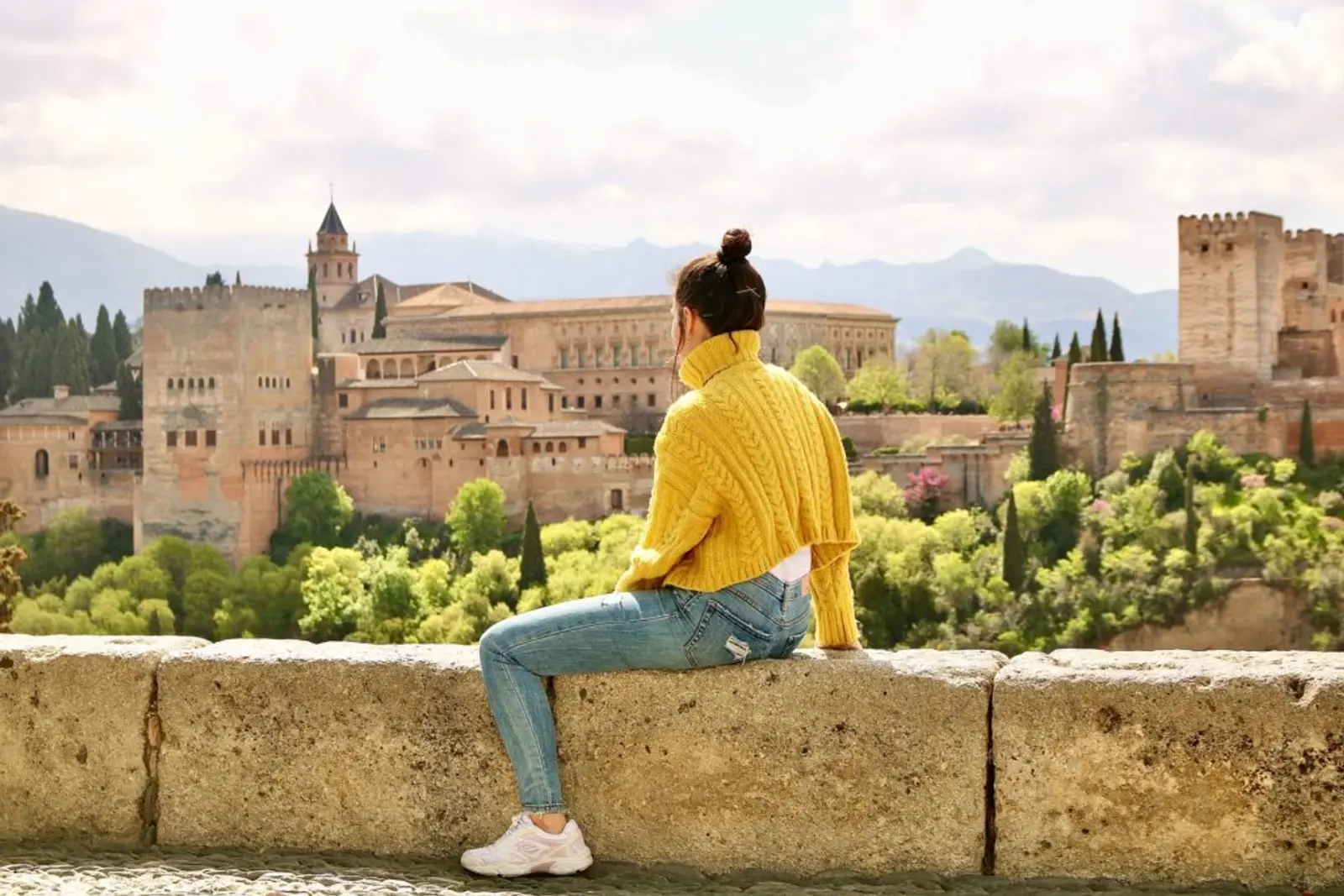 Persona sentada observando la ciudad de Granada desde un mirador