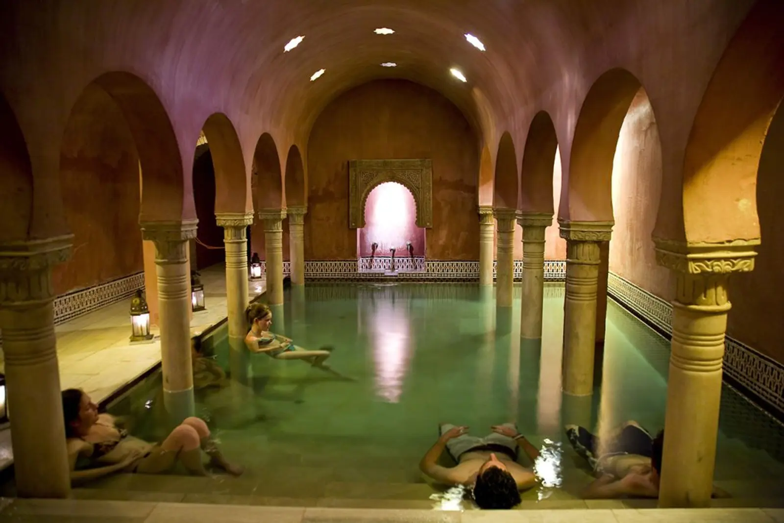Interior de baños termales con personas descansando en Granada